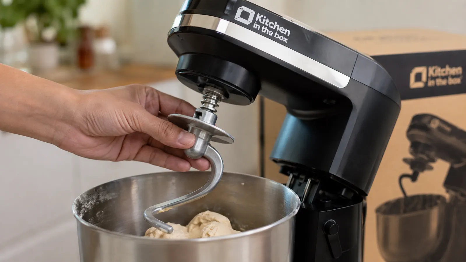 Hand attaching the dough hook to the compact stand mixer before kneading bread dough