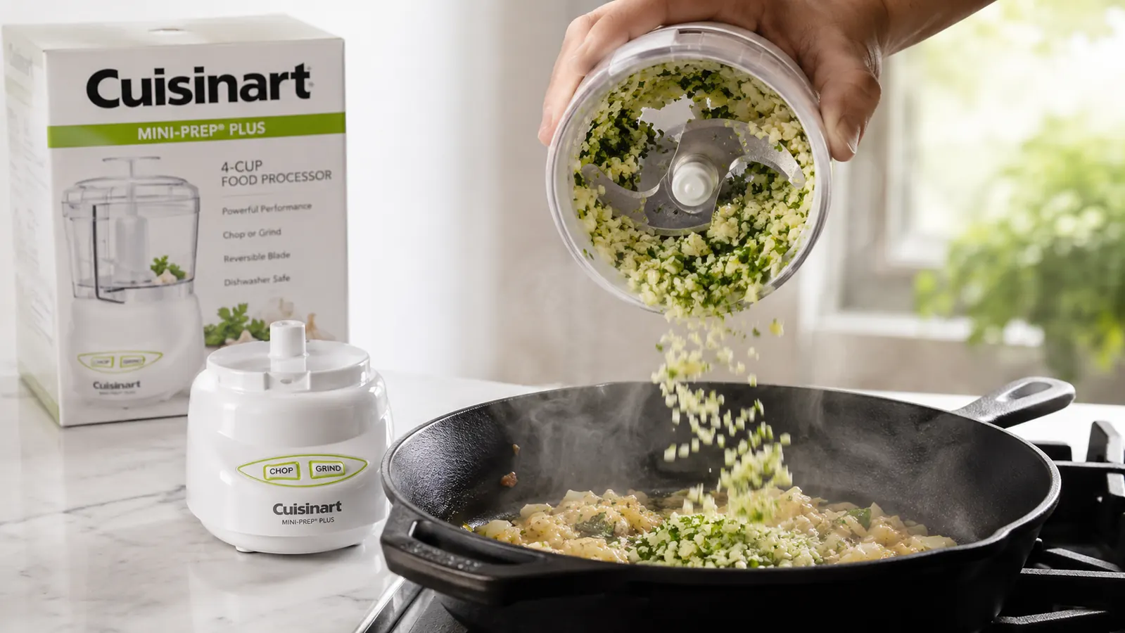 Hand lifting the work bowl off the base to pour minced garlic and herbs directly into a skillet