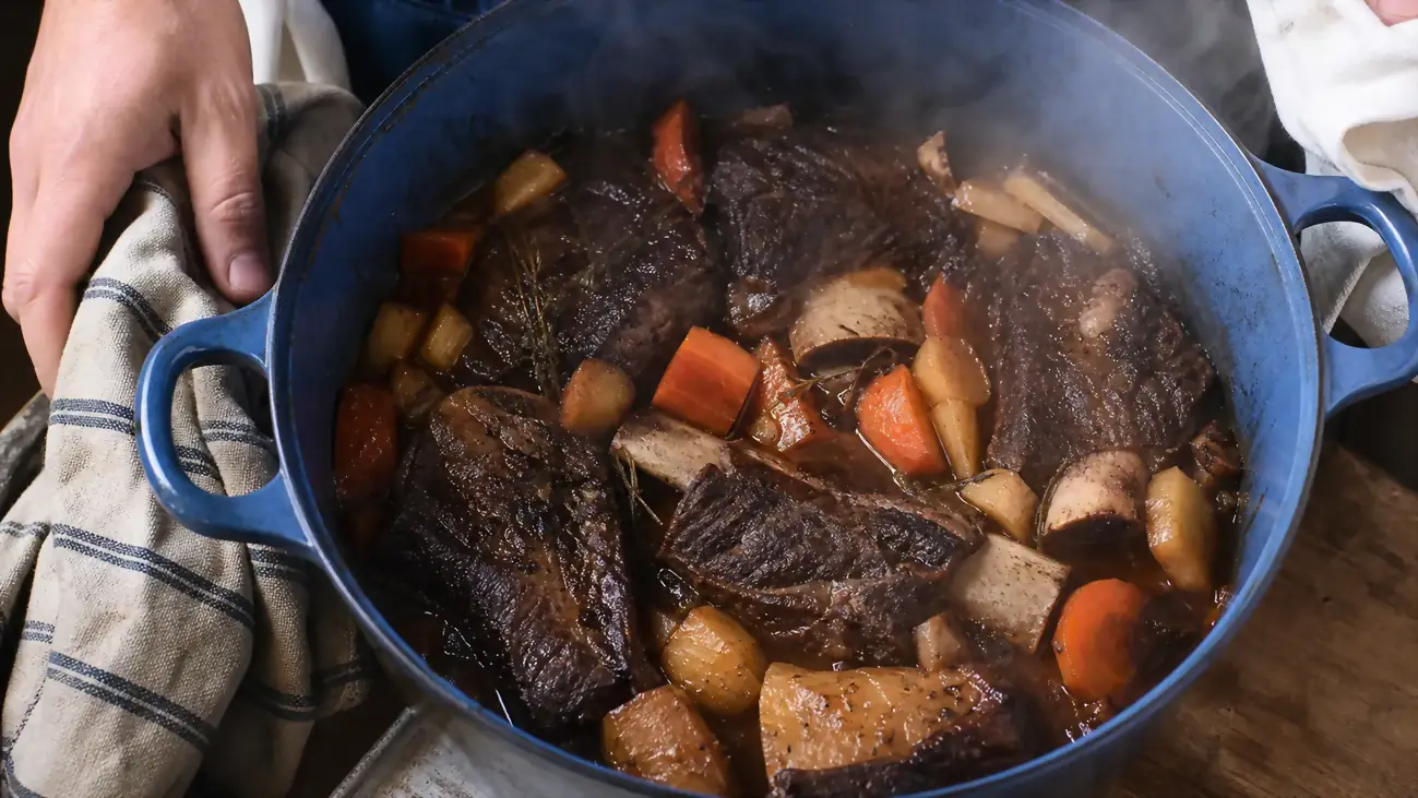 Finished braised short ribs and vegetables inside the open Lodge braiser, fresh from the oven